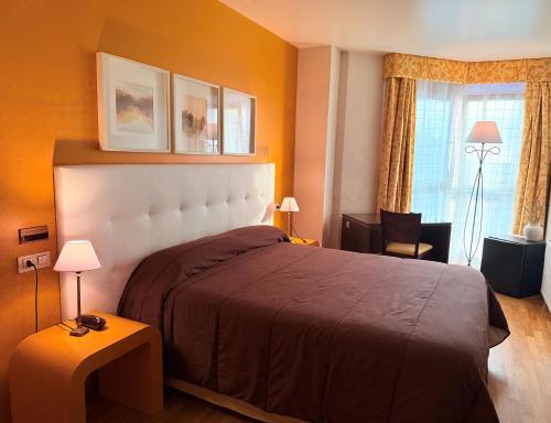 a bedroom with a large bed and a window at Hotel Bouza in Ribadeo