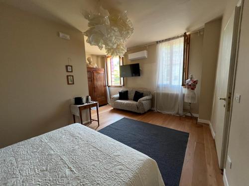 a bedroom with a bed and a couch in it at Casa Agostini Bed and Breakfast in Farra di Soligo