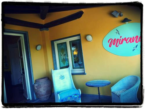 a building with a chair and a stool in front of it at Locanda Miranda in Tellaro