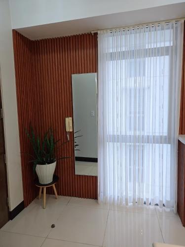 a living room with a large window and a plant at Cozy Corner at Manhattan Heights Tower B 2BR ,2BA Amazing View in Manila