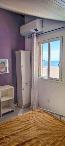 une chambre avec un réfrigérateur et une fenêtre avec la plage dans l'établissement Bright Rooftop F3 Terrace Sea & Mountain View, à Bastia