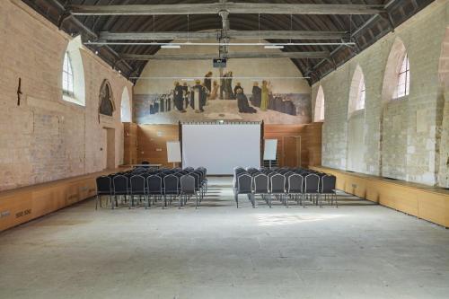 an empty room with chairs and a white screen at Appart'hôtel Odalys City - Dijon Centre Les Cordeliers in Dijon