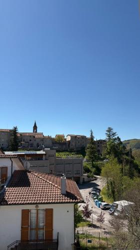a white house with a red roof and a parking lot at Casa Vacanze Nuvola in Pietralunga