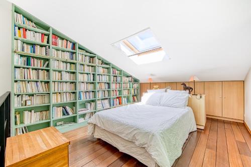 a bedroom with green book shelves and a bed at La maison du Médoc in Avensan