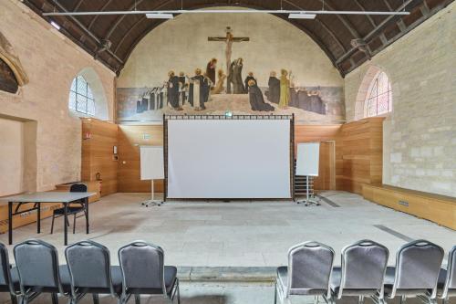 a large room with a white screen in a church at Appart'hôtel Odalys City - Dijon Centre Les Cordeliers in Dijon