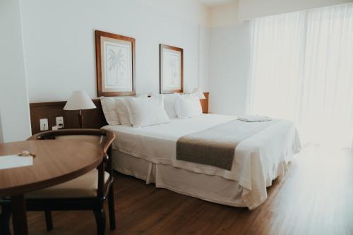 a bedroom with a large bed and a table at Timbó Park Hotel in Timbó
