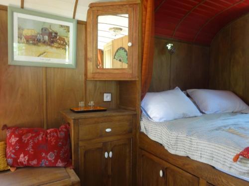 une petite chambre avec un lit et un miroir dans l'établissement Gite provençal de Montigal, à Bagnols-sur-Cèze