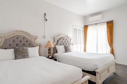 a white bedroom with two beds and a window at Anniversario in Onna