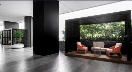 a living room with a couch and chairs in a building at Wanderlust Retreat Studio by Iconic Regency in Bayan Lepas