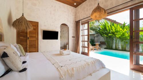 een slaapkamer met een bed en een zwembad bij Nick Villas by Villa Finder in Ubud