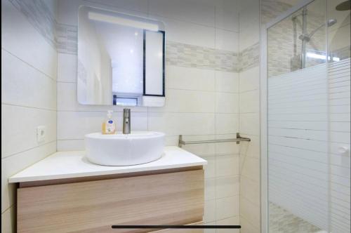 une salle de bain blanche avec un lavabo et une douche dans l'établissement studio centre port de nice, à Nice