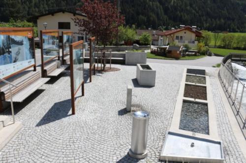 a patio with a bunch of benches at Pension Fuchs in Pfunds