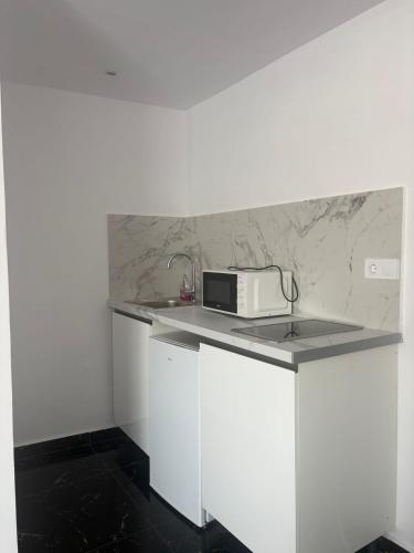 a white kitchen with a microwave on a counter at SL Marbella in Marbella