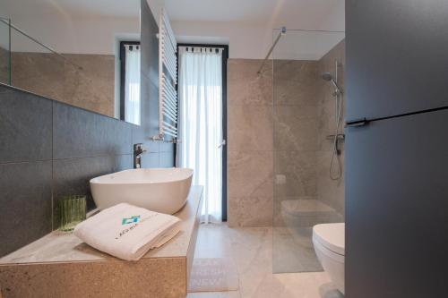 a bathroom with a tub and a sink and a toilet at Laguna Beskidów Resort - Apartament Panorama in Zarzecze
