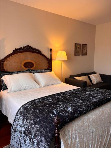 a bedroom with a large bed and a chair at CASA das Leiras in Vieira do Minho