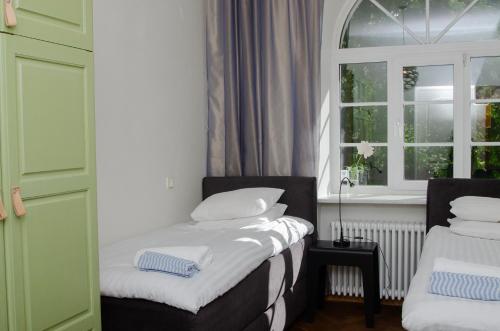 two beds in a room with a window at Large 3-room apartment in a historic house in Tallinn