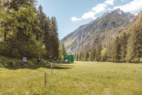 a field of grass with a mountain in the background at Pension Fuchs in Pfunds