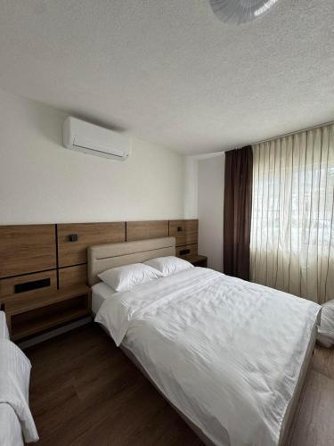 a bedroom with a large white bed and a window at Villa Hanna Ilidža in Kamenjača