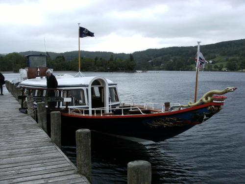 a boat is docked at a dock on the water at Glen Wynne Windermere - FREE off-site Health Club access with Pool, Sauna, Steam Room & Gym Short 5 Minute Drive Away in Windermere