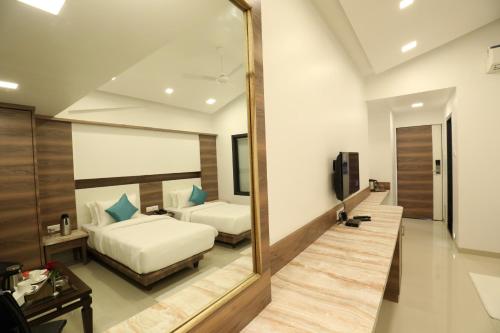a bedroom with a large mirror and a bed at Imperial Grande Resort in Lonavala