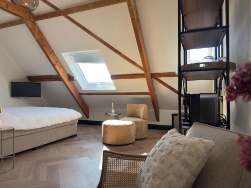 a bedroom with a bed and a couch and a table at Herbergh Rehoboth in Heelsum
