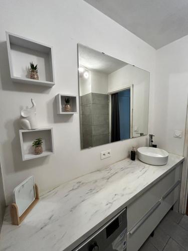 une salle de bain blanche avec un lavabo et un miroir dans l'établissement Le PassaChristo, à Bandol