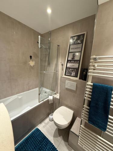 une salle de bain avec une baignoire, des toilettes et une douche dans l'établissement Appartement Roland Garros PSG, à Boulogne-Billancourt