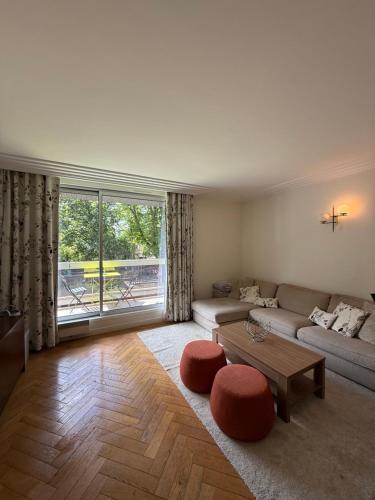 un salon avec un canapé et une table dans l'établissement Appartement Roland Garros PSG, à Boulogne-Billancourt