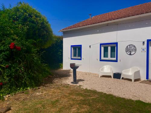 a white building with two chairs and a table at Pine 3 Inn, holiday home, activities and more in Boavista dos Pinheiros