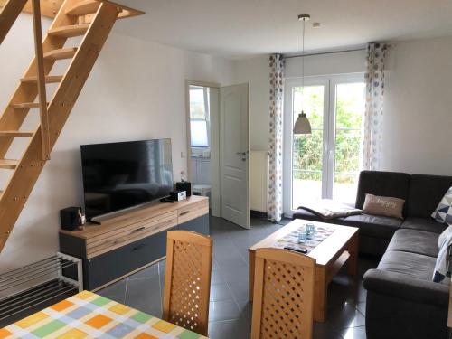 a living room with a couch and a television at Bernstein-Fewos ca 15 Gehminuten zum Ostseestrand in Zempin