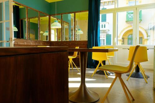 a dining room with a table and yellow chairs at TheVillaRose in Wimereux