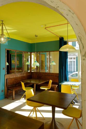 a dining room with tables and yellow chairs at TheVillaRose in Wimereux