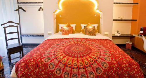a bedroom with a large bed with a red bedspread at PLAZA INN stays design Dortmund in Dortmund