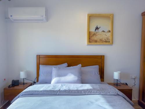 a bedroom with a bed with a picture on the wall at Le Royal Museum & Giza Pyramids view in Cairo