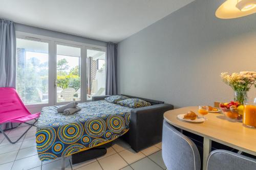 - un salon avec un lit, une table et une salle à manger dans l'établissement Appartement proche océan - piscine - terrasse - parking, à Moliets-et-Maa