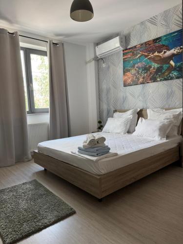 a bedroom with a large bed and a painting on the wall at Lira Holiday Apartments in Eforie Nord