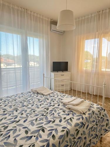 a bedroom with a bed and a tv and windows at Appartamento Debbis Home Misano Adriatico in Misano Adriatico