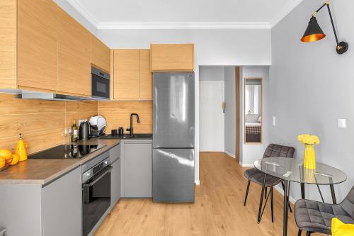 une cuisine avec un réfrigérateur en acier inoxydable et une table dans l'établissement Gorgeous apartment in the center, à Nice