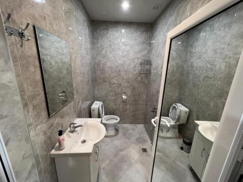 a bathroom with two toilets and a sink and a shower at Апарт Хотел Любимец in Lyubimets