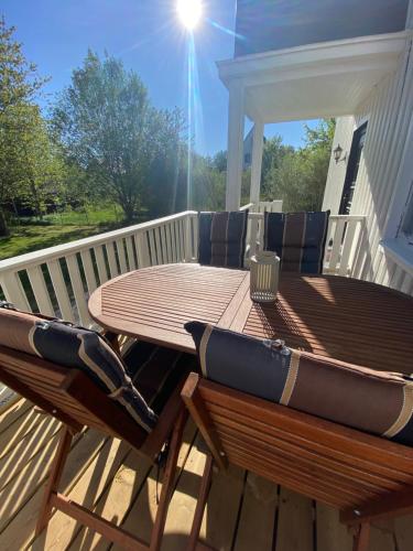 a wooden table and chairs on a deck at Ferienhaus Luise, Kalles Ferienwohnung in Rörvik
