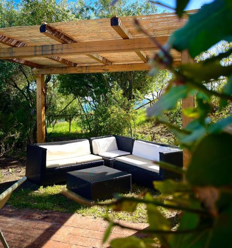 a black and white couch under a wooden pergola at La Locanda Volpaia in Radda in Chianti
