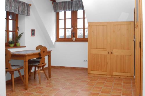 a kitchen with a wooden table and chairs and a door at Hájenka hraběte Buquoye in Kaplice
