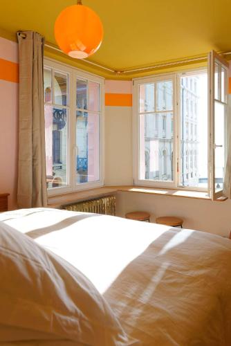 a bedroom with a white bed and two windows at TheVillaRose in Wimereux
