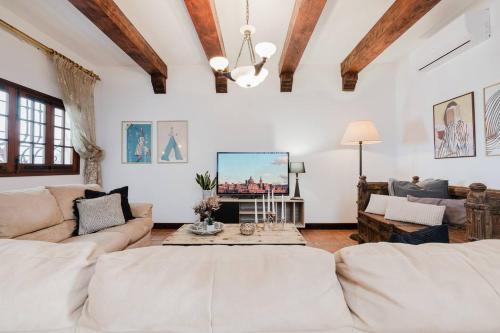 a living room with white furniture and wooden ceilings at The Rustique - 3BED house in Mellieha by Homely! in Ix-Xagħra taʼ Barra