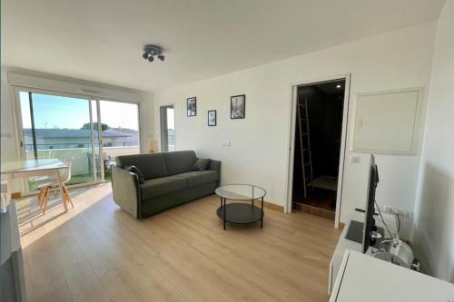 un salon avec un canapé et une table dans l'établissement Charming modern apartment with terrace, à La Rochelle