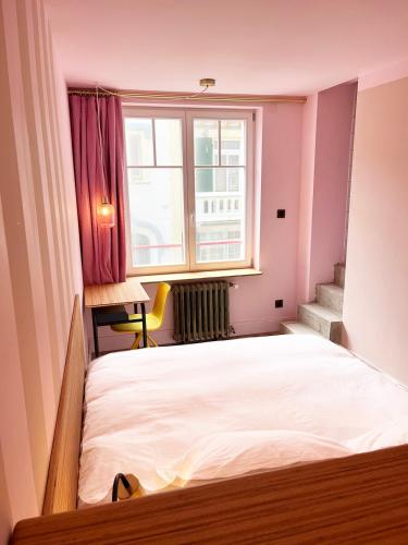 a small bedroom with a bed and a window at TheVillaRose in Wimereux