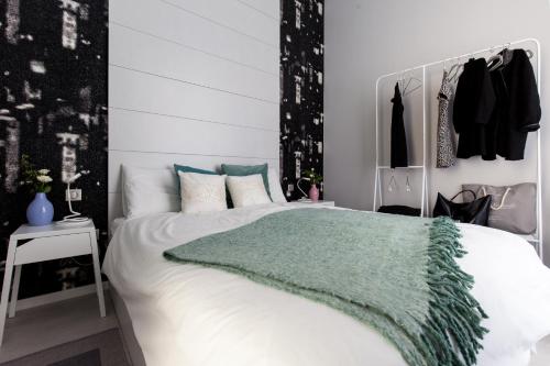1 dormitorio con 1 cama blanca con manta verde en Boutique Apartment in Budapest Downtown, en Budapest