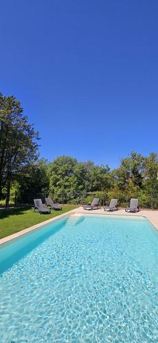 une grande piscine avec des chaises et de l'eau bleue dans l'établissement F5 Escapade, maison, lac, riviére, Rabinon ,VAR., au Muy