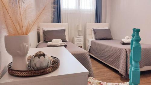 a room with two beds and a vase on a table at MGE Luxury house with pool in Iraklitsa