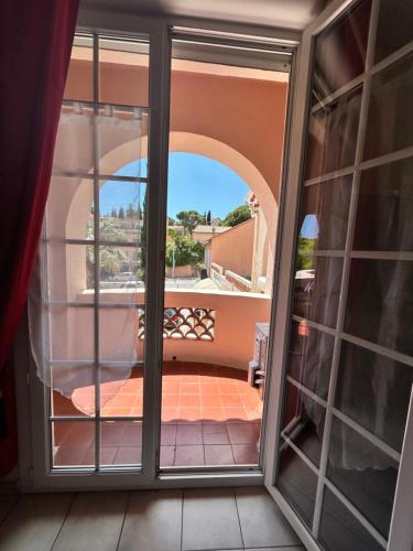 d'une porte coulissante en verre avec vue sur un balcon. dans l'établissement Studio avec Grand Balcon- Résidence de Caractère, à Bandol